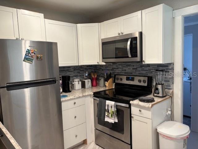 1408 San Juan Ct, Clearwater, FL 33756 - kitchen with appliances with stainless steel finishes, white cabinets, and decorative backsplash