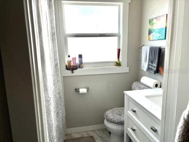 1408 San Juan Ct, Clearwater, FL 33756 - bathroom with vanity, toilet, marble look tiles, and baseboards