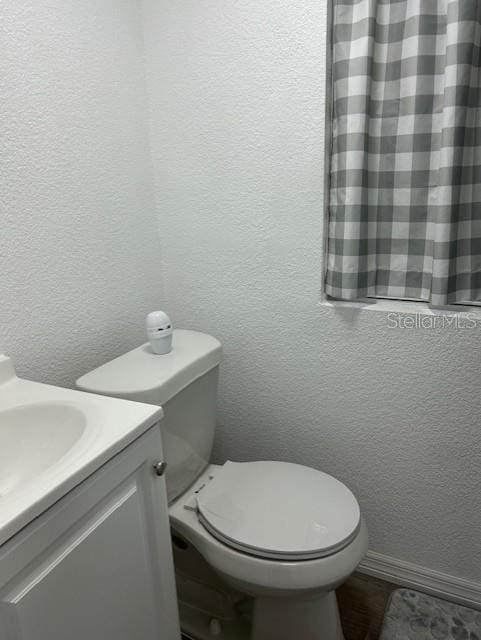 1408 San Juan Ct, Clearwater, FL 33756 - bathroom featuring toilet, vanity, and a textured wall