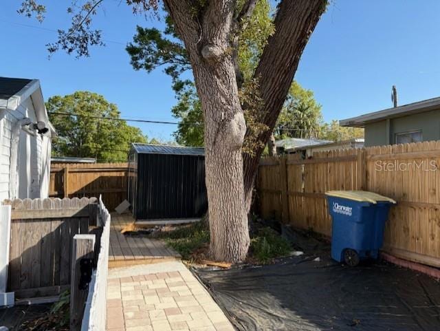1408 San Juan Ct, Clearwater, FL 33756 - fenced backyard featuring a storage unit, an outdoor structure, and a patio area
