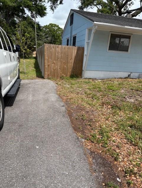 1408 San Juan Ct, Clearwater, FL 33756 - view of side of property with fence and a shingled roof