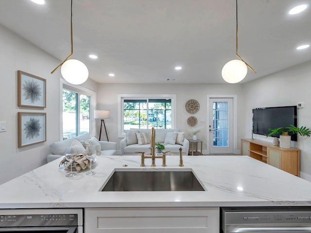 kitchen with stainless steel dishwasher, open floor plan, light stone countertops, and recessed lighting