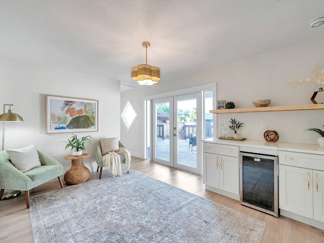interior space featuring white cabinetry, light countertops, open shelves, wine cooler, and light wood-style floors