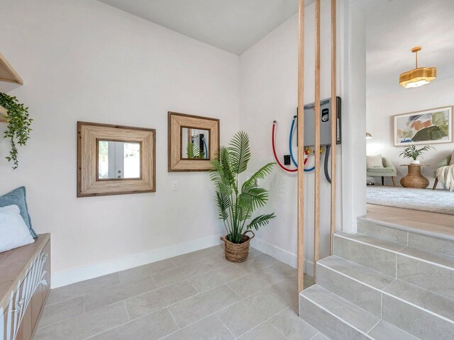 hall with baseboards and light tile patterned floors