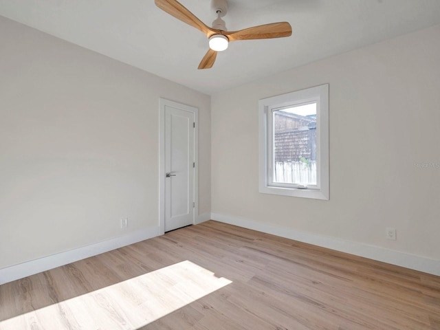 empty room with baseboards, ceiling fan, and light wood-type flooring