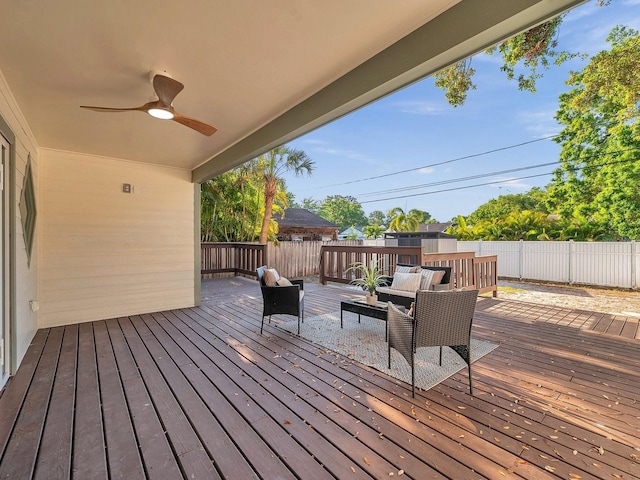 wooden terrace with outdoor lounge area, fence, and ceiling fan