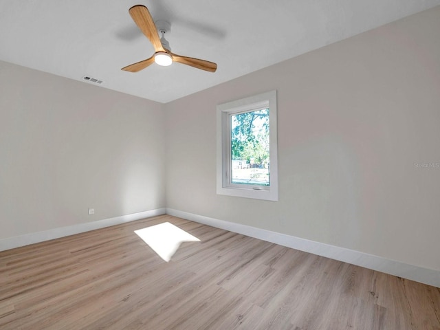 spare room featuring baseboards, visible vents, and light wood-style floors