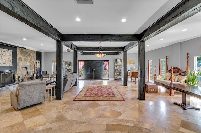 entrance foyer featuring beamed ceiling, plenty of natural light, and visible vents