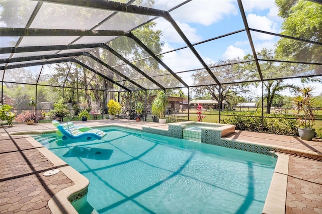 view of swimming pool with glass enclosure, a pool with connected hot tub, and a patio