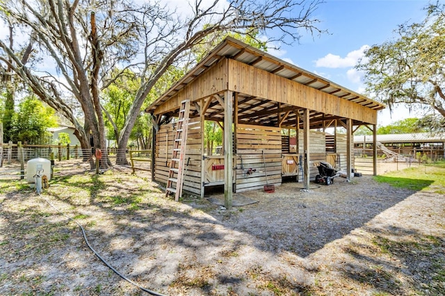 view of outbuilding with an exterior structure, an outdoor structure, and fence