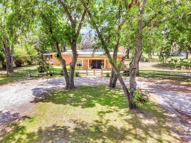 view of front of property featuring a front lawn, fence private yard, and stucco siding