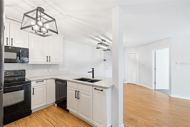 2314 S Clewis Ct Unit 106, Tampa, FL 33629 - kitchen featuring black appliances, a sink, light wood-style floors, a chandelier, and tasteful backsplash