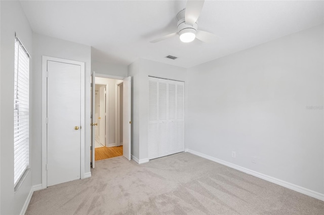 2314 S Clewis Ct Unit 106, Tampa, FL 33629 - unfurnished bedroom featuring light colored carpet, baseboards, a ceiling fan, and a closet
