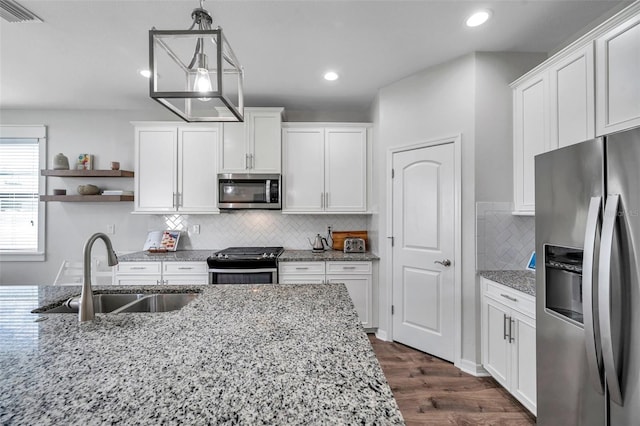 kitchen featuring visible vents, white cabinetry, a sink, and stainless steel appliances