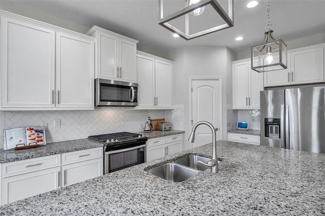 kitchen with white cabinetry, light stone countertops, a sink, and stainless steel appliances