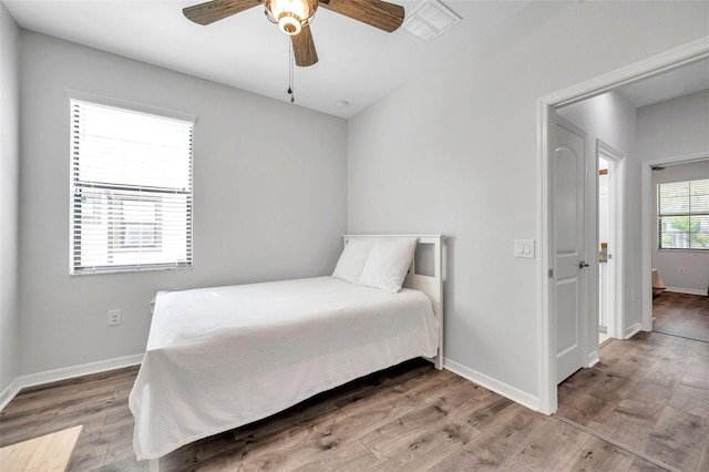 bedroom with a ceiling fan, baseboards, and wood finished floors