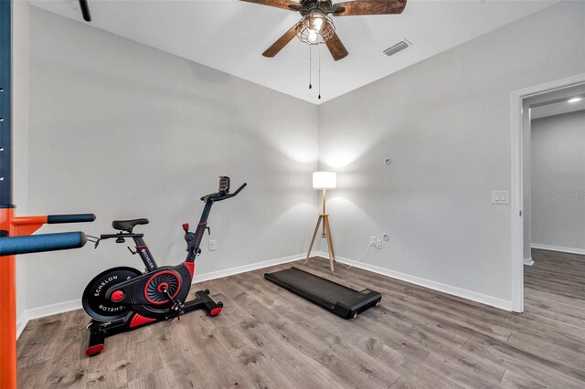 workout room featuring baseboards, ceiling fan, visible vents, and wood finished floors