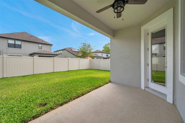 view of yard with fence and a ceiling fan