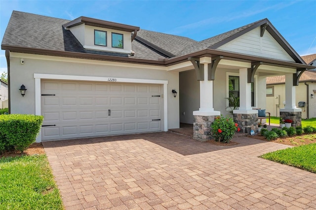 view of front of home with stucco siding, a garage, and decorative driveway
