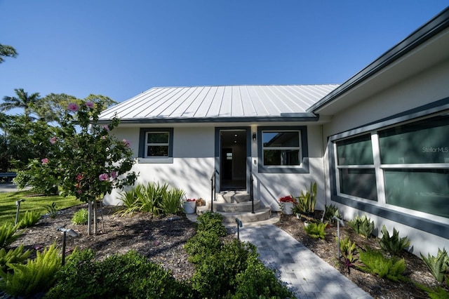 3986 Bennett Ln, Bonita Springs, FL 34134 - view of exterior entry with stucco siding, metal roof, and a standing seam roof