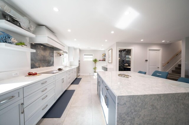 3986 Bennett Ln, Bonita Springs, FL 34134 - kitchen featuring open shelves, recessed lighting, black electric stovetop, a kitchen island, and a sink