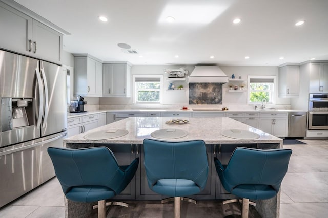 3986 Bennett Ln, Bonita Springs, FL 34134 - kitchen featuring stainless steel appliances, a kitchen breakfast bar, custom range hood, and open shelves