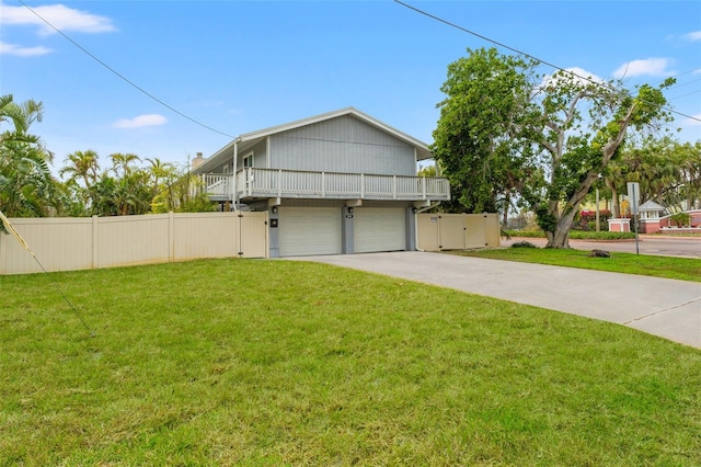exterior space with concrete driveway, a garage, fence, and a front lawn