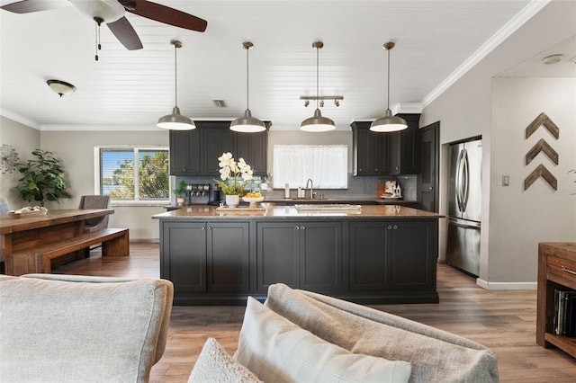 kitchen featuring light wood finished floors, a ceiling fan, crown molding, and freestanding refrigerator
