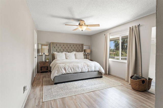bedroom with baseboards, light wood-style flooring, ceiling fan, and a textured ceiling