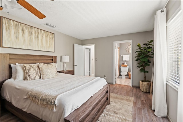 bedroom with light wood-style flooring, visible vents, ceiling fan, connected bathroom, and multiple windows