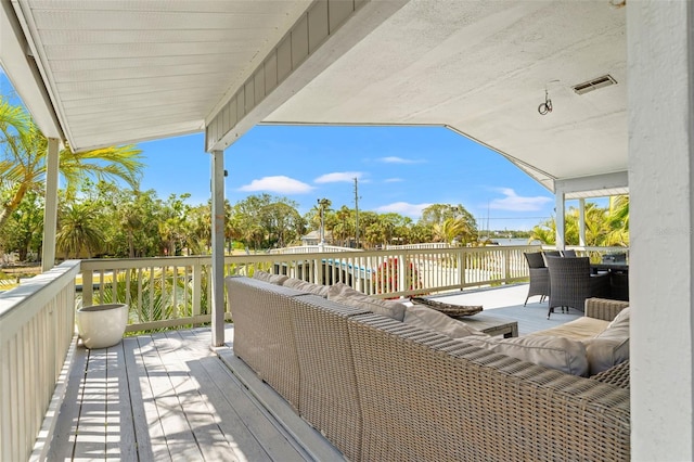 wooden deck with an outdoor living space, outdoor dining area, and visible vents
