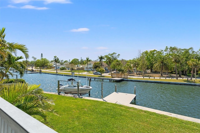 view of dock with a water view and a yard