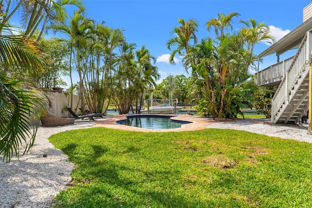 view of yard with stairs and an outdoor pool
