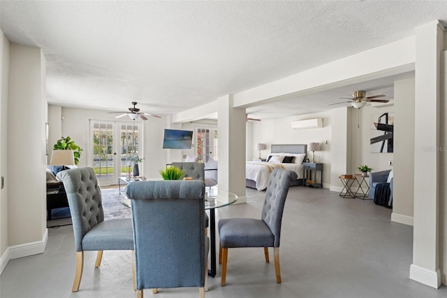 dining area featuring concrete flooring, a textured ceiling, a wall mounted air conditioner, and ceiling fan