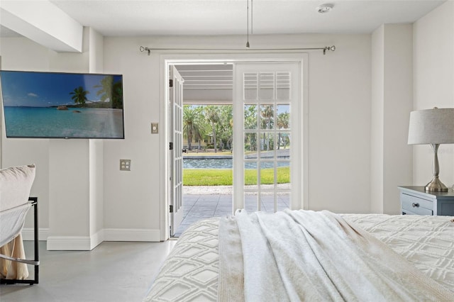 bedroom with baseboards, access to exterior, and concrete flooring
