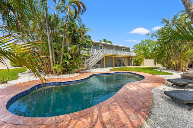 outdoor pool featuring a patio, fence, a wooden deck, and stairway