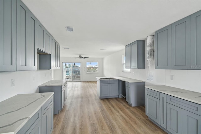 15621 Bertram Dr, Hudson, FL 34667 - kitchen with light stone countertops, light wood-style floors, and ceiling fan