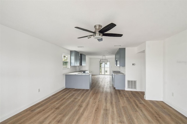 15621 Bertram Dr, Hudson, FL 34667 - unfurnished living room featuring wood finished floors, a ceiling fan, and baseboards