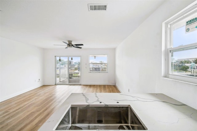 15621 Bertram Dr, Hudson, FL 34667 - unfurnished living room featuring wood finished floors, ceiling fan, and baseboards