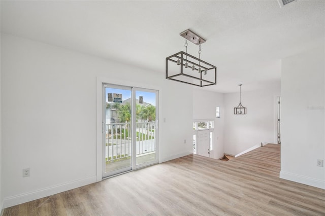 15621 Bertram Dr, Hudson, FL 34667 - unfurnished dining area with wood finished floors, a chandelier, and baseboards