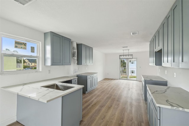 15621 Bertram Dr, Hudson, FL 34667 - kitchen with a peninsula, wood finished floors, light stone counters, and baseboards