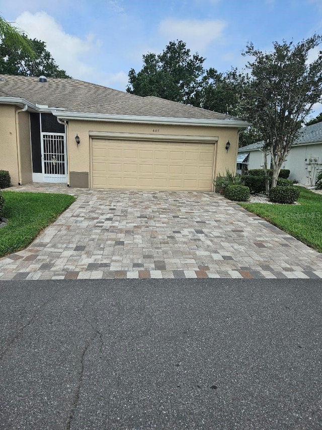 607 Manchester Woods Dr Unit 84, Sun City Center, FL 33573 - ranch-style home featuring decorative driveway, a garage, stucco siding, and roof with shingles