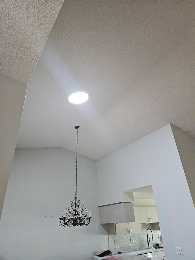 607 Manchester Woods Dr Unit 84, Sun City Center, FL 33573 - detailed view of a sink, modern cabinets, decorative backsplash, a chandelier, and light countertops