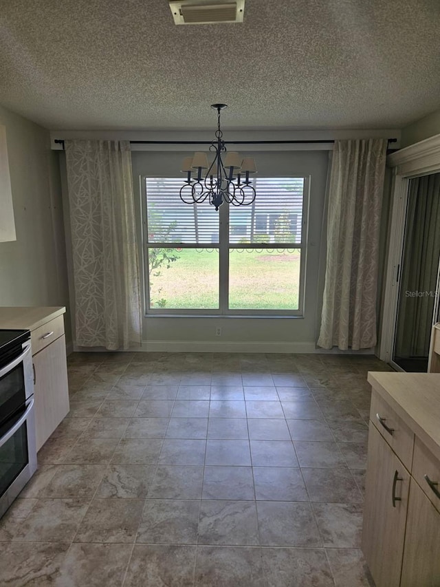607 Manchester Woods Dr Unit 84, Sun City Center, FL 33573 - unfurnished dining area with a chandelier, a textured ceiling, and baseboards