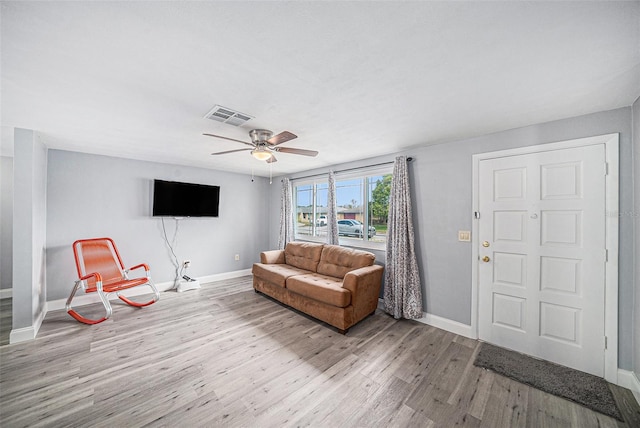living area with wood finished floors, baseboards, ceiling fan, and visible vents