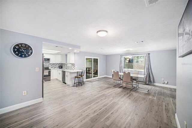 interior space featuring plenty of natural light, baseboards, visible vents, and light wood finished floors