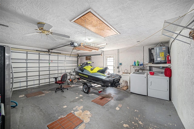 garage featuring a sink, independent washer and dryer, a garage door opener, and electric water heater