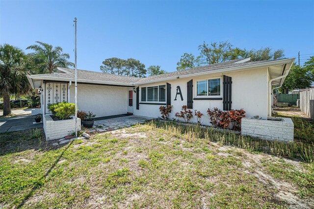 ranch-style home featuring stucco siding and fence