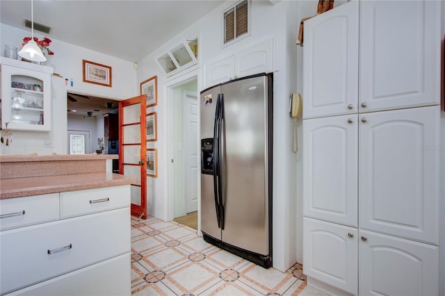 921 24th Ave N, Saint Petersburg, FL 33704 - kitchen with stainless steel refrigerator with ice dispenser, white cabinets, glass insert cabinets, decorative light fixtures, and light countertops
