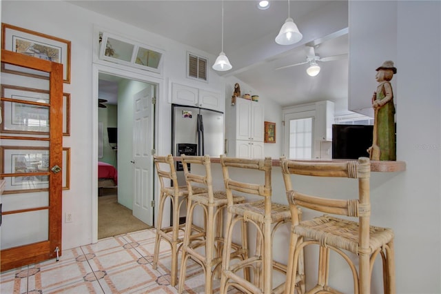 921 24th Ave N, Saint Petersburg, FL 33704 - kitchen with lofted ceiling, white cabinets, a breakfast bar, light carpet, and pendant lighting